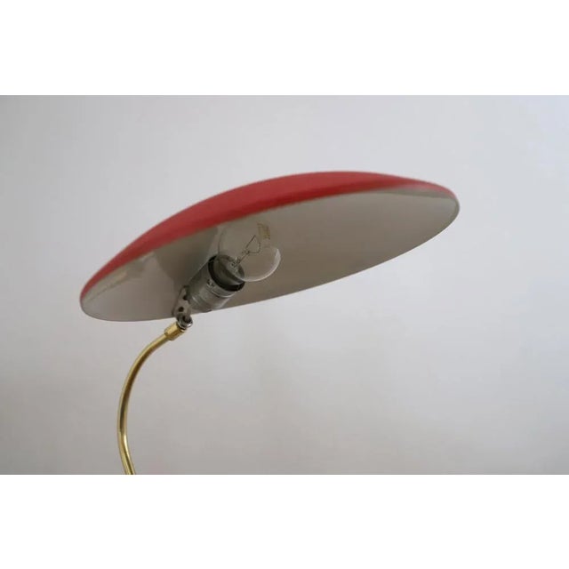 This (writing) table lamp is an Austrian design classic from the 1950s. The curved brass arm and the large, flat umbrella,...