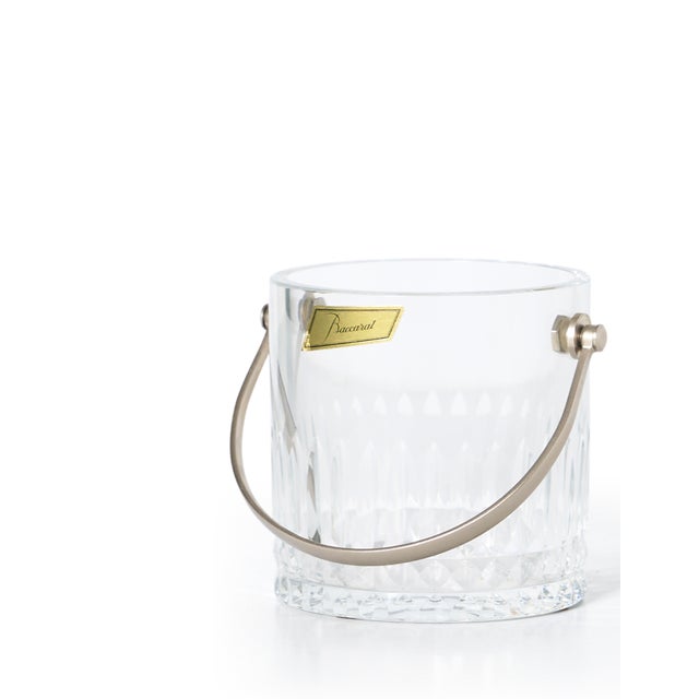 Sourced in France, this beautiful crystal ice bucket from Baccarat has vertical cuts on the side with a silver handle....