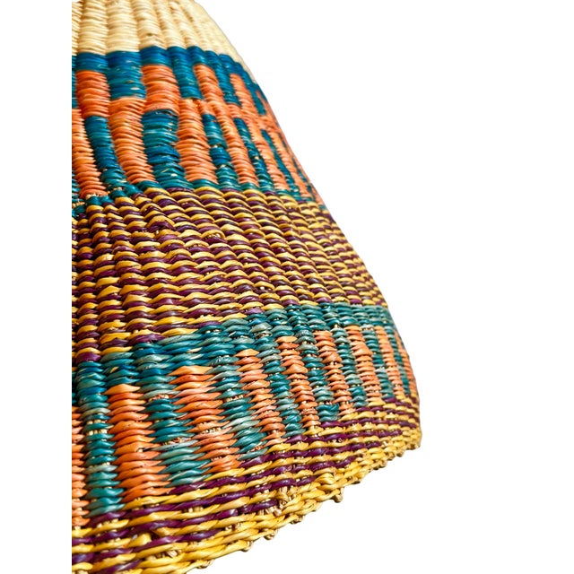 This pendant light began as a traditional Bolga basket from northern Ghana. These baskets were objects of daily use, woven...