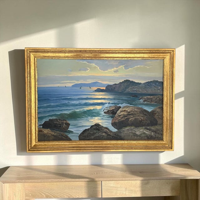 A luminous signed oil on board seascape depicting the rugged coastline of Capri, attributed by a handwritten note affixed...