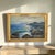 A luminous signed oil on board seascape depicting the rugged coastline of Capri, attributed by a handwritten note affixed...