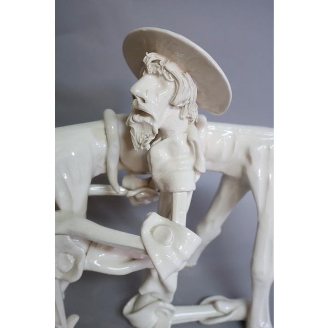 Expressive and highly stylized porcelain sculpture depicting Don Quixote beside his weary horse, rendered in an elongated...