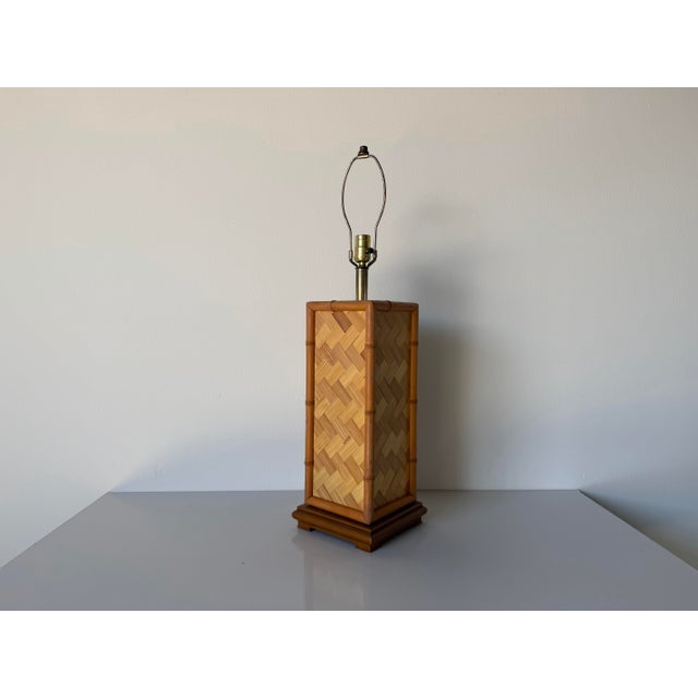 Charming vintage table lamp featuring a faux bamboo frame with woven rattan panels in a striking herringbone pattern. The...
