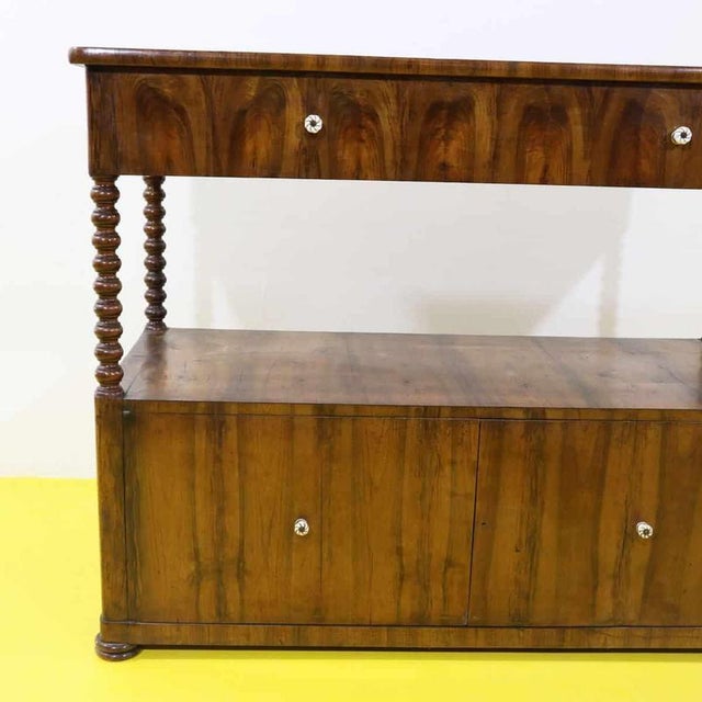 Wooden cabinet featuring turned columns and ceramic knobs.