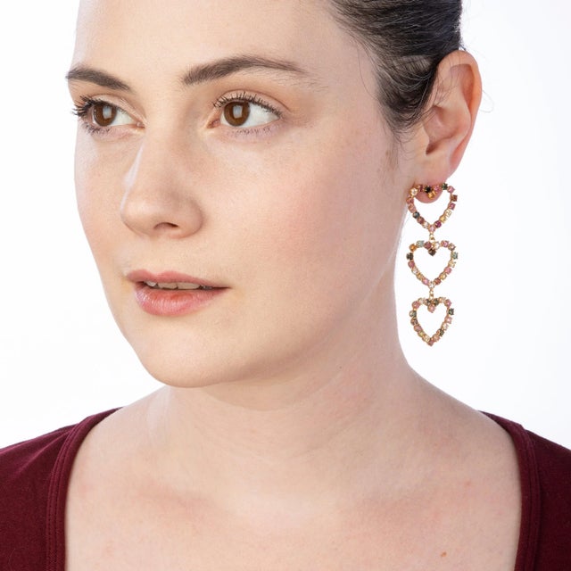 The Renee Earrings, crafted from semiprecious stones, showcase heart-shaped tourmaline elements. Their detachable feature...