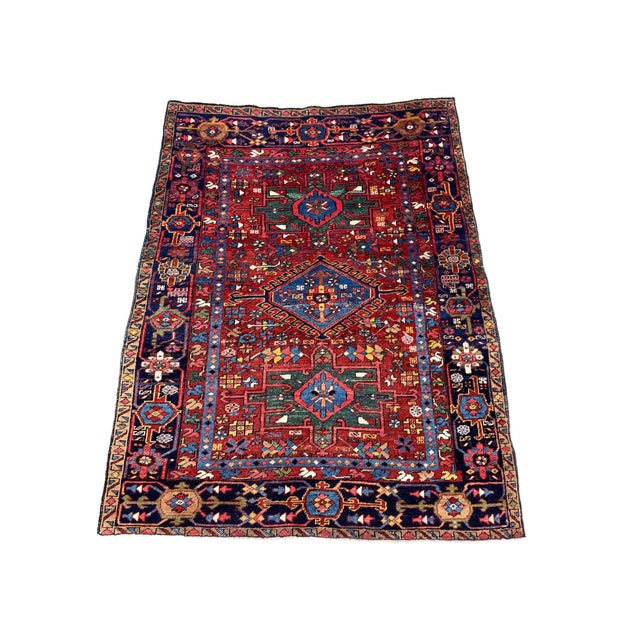 A beautiful antique Heriz rug, handwoven circa 1910 with a geometrical 3 medallion design on a rich terracotta field and...