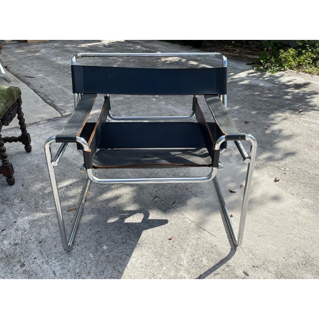Mid Mod Wassily style chair in black leather Inspired by Marcel Breuer’s 1925 Bauhaus masterpiece, this iconic sling chair...