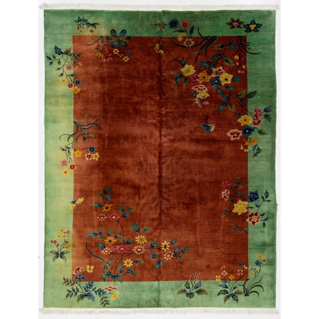 Beautiful antique Art Deco Chinese hand-knotted wool rug with a brown field. This Chinese rug has a green frame and...