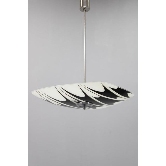 This exceptional Mid Century Modern pendant lamp was produced in Czechoslovakia in the 1960s. The design showcases a hand-...