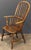 A handsome Windsor high back armchair of elm from Georgian era England, featuring a bowed top rail and spindle back, with...