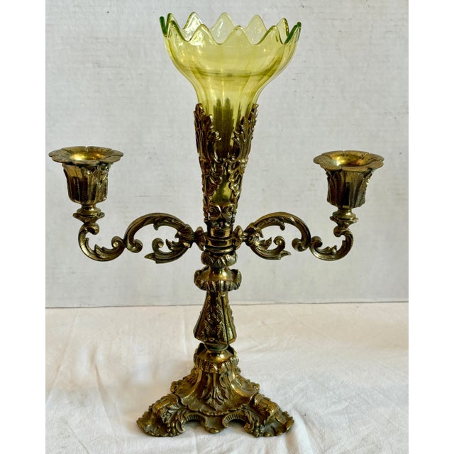The fine epergne is fitted with a yellowish / green scalloped glass holder and is flanked by a pair of extended arms for...