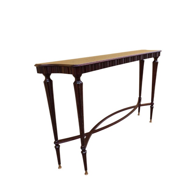 An elegant mahogany console table, featuring a refined design inspired by the style of Paolo Buffa. The frame is supported...