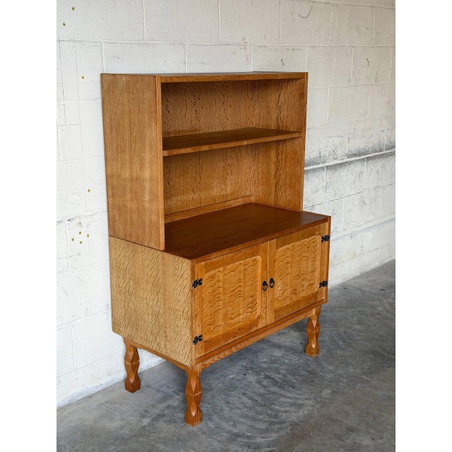 This versatile oak cabinet combines open upper display shelving with enclosed lower cabinet storage. Raised on distinctive...