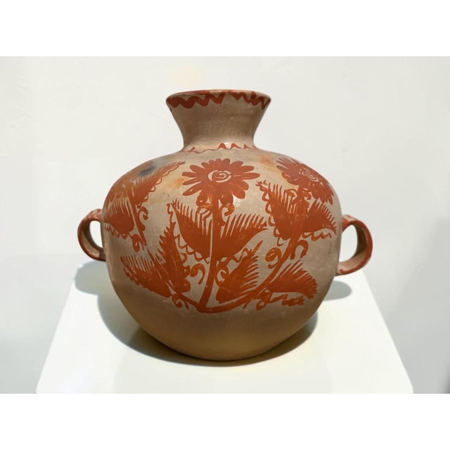 Charming vintage Mexican folk art pottery vase featuring a rounded body, flared neck, and two decorative loop handles....