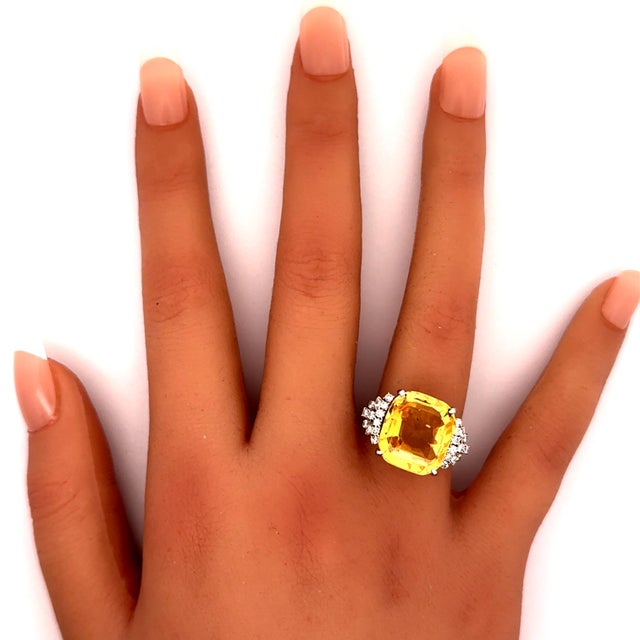 A striking contemporary ring crafted in platinum, featuring a magnificent 14.66-carat cushion-cut yellow sapphire. The...
