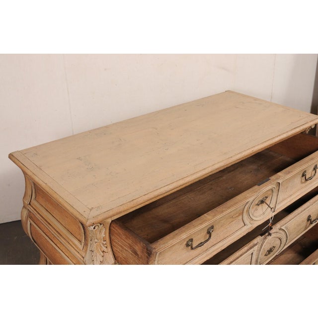 An exquisitely beautiful French Louis XV carved-wood bombé commode, or chest of drawers, from the 18th century. This...