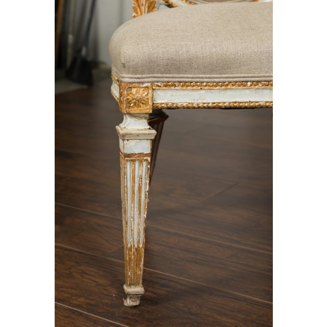 A pair of Italian 1790s neoclassical painted and carved side chairs with shield backs and traces of gilt. This pair of...