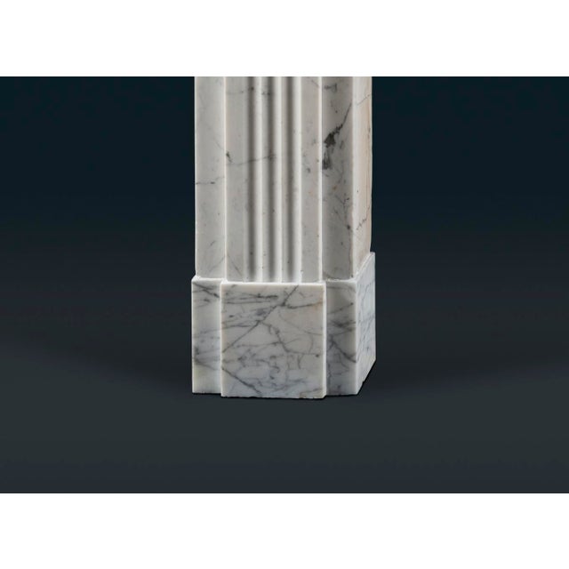 A handsome late Georgian or Regency period fireplace surround carved in delicate and lightly veined pencil veined Statuary...