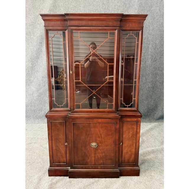 This vintage mahogany bookcase/china cabinet features a stately design with a glass-paneled upper section showcasing...