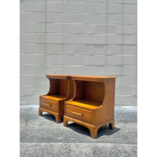 Warm and quietly sculptural, this pair of vintage pecan wood nightstands balances clean lines with softened architectural...