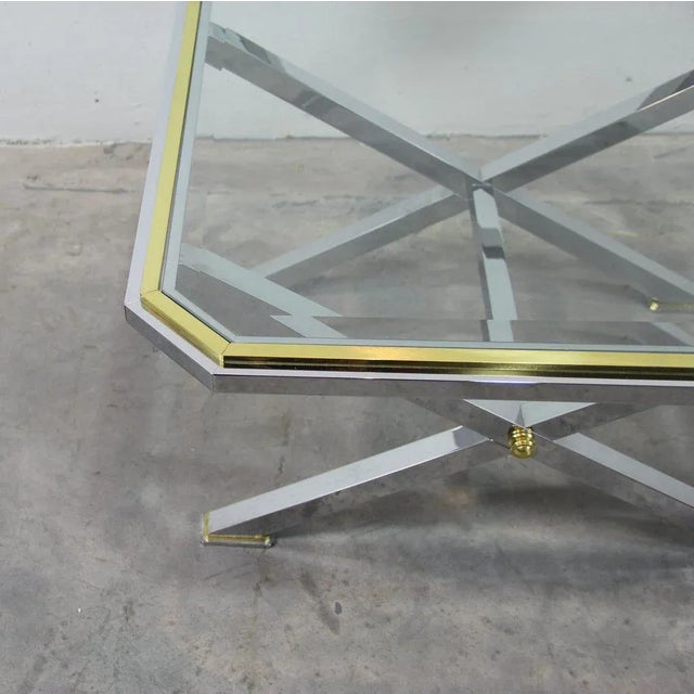 This Italian coffee table is made in gold and chrome brass and has a thick beveled glass top.