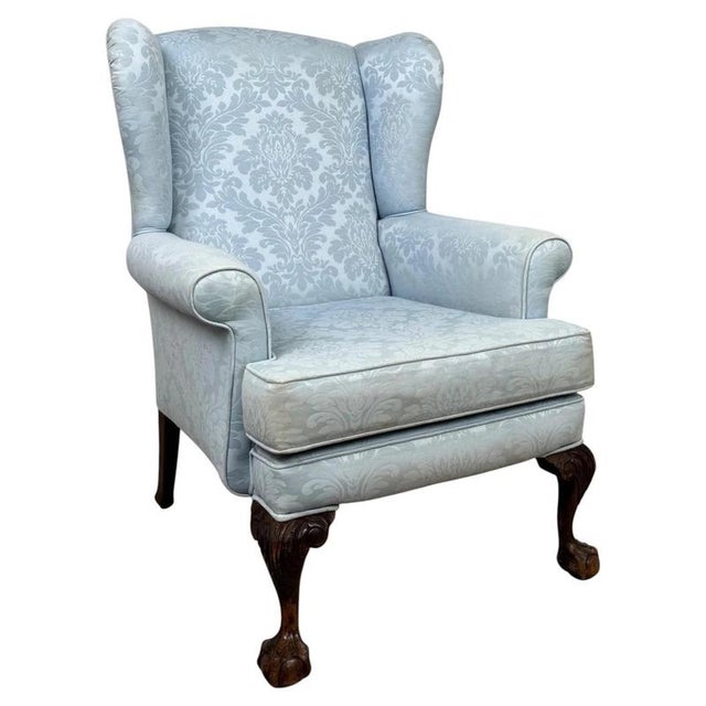 A handsome early 20th-century English wingback armchair, finely constructed from oak and distinguished by its traditional...