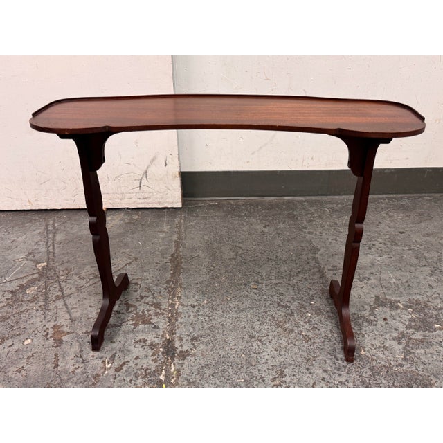 Design Plus Gallery presents an Antique Kidney-Shaped Reading/Altar Table in the style of Elsie de Wolfe. The mahogany-...