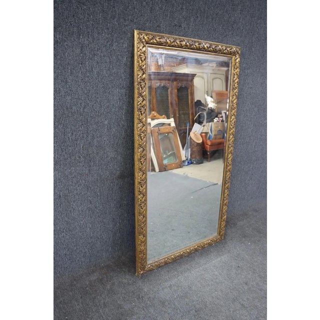 Beveled leaner mirror with carved gilded accents
