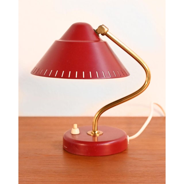 Scandinavian table lamp from the 1950s with a brass stem, base, and shade in wine-colored lacquered metal. This table...