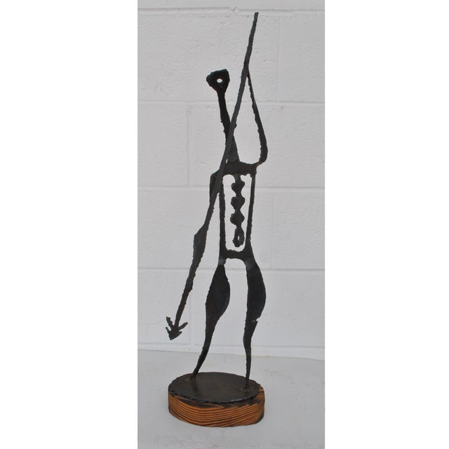 Mid-Century Modernist Brutalist metal sculpture depicting a spear carrying warrior. The scorched torch cut molten metal is...