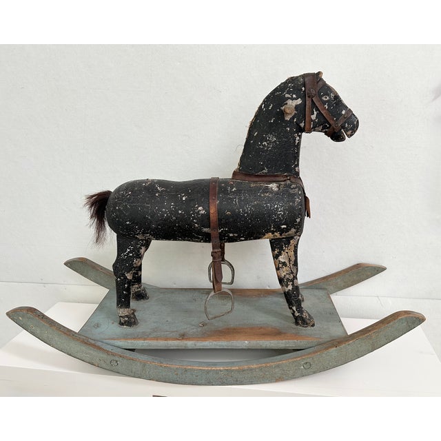 This antique rocking horse is a truly unique decorative item. The charming horse features a deeply weathered black finish...