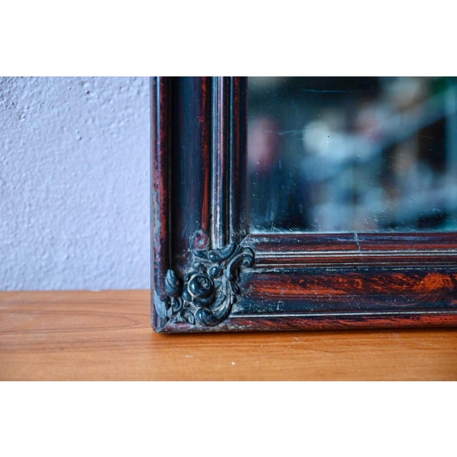 This antique mirror exudes bohemian chic charm! Its frame is adorned with a carefully painted faux wood finish,...