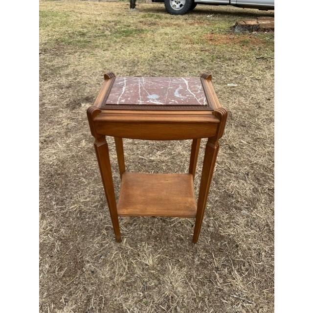 A French Art Deco Marble top four legs two-tier accent table, circa 1940s. Made of walnut, the wood has been finished with...