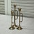 Set of three brass bugle candleholders. Measure 2.5” diameter at bottom and 9.25”, 8.25”h and 7.25”h.