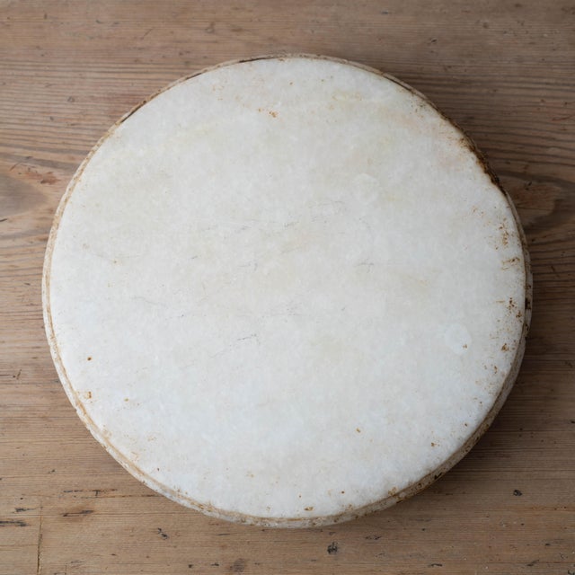 Indian white marble chapati riser (chakla stand) with slightly convex top, central carved 5-petal daisy flower on...