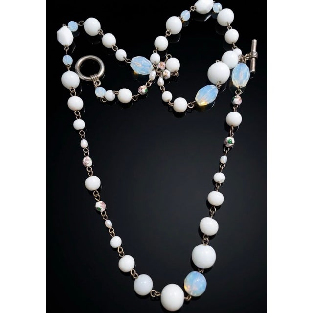 A captivating statement necklace of opaque milk glass and iridescent opaline beads. Woven throughout are intricate floral...