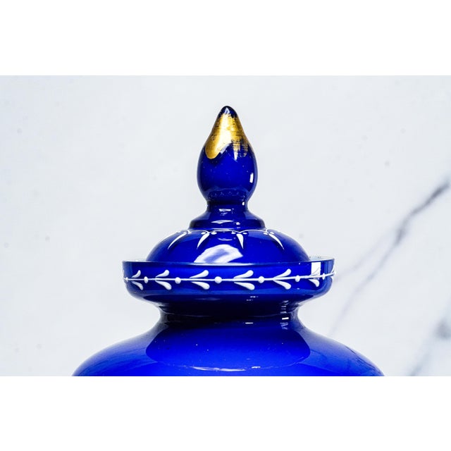 Elevate your décor with this exquisite Victorian lidded vase, a captivating work of hand-blown artistry in rich cobalt...