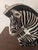 Striking vintage zebra sculpture featuring a bold black and white pattern and a sculptural, resting pose. This eye-...
