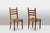 Set of 8 oak chairs with straw-seated seats; the backs are topped with decorative balls. Realzied in the 1950s. This piece...