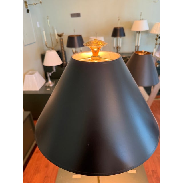 A table lamp featuring a polished brass urn accented by a slender column and classical handles. Inspired by Hellenic...