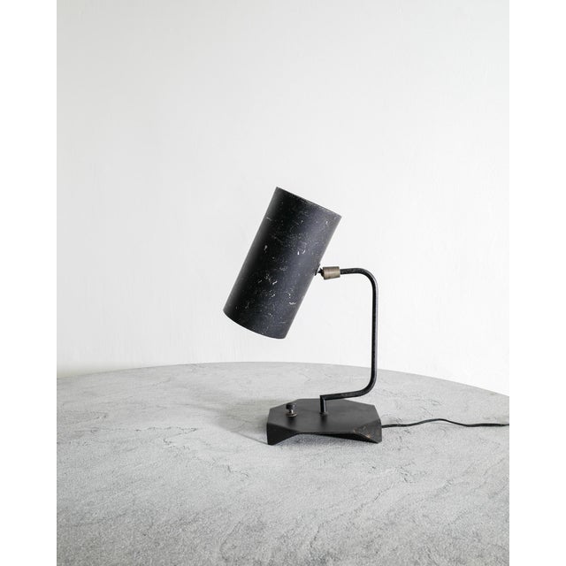 A very rare mid century " tuyaux" desk table lamp in black lacquered metal and patinated brass with an adjustable shade by...