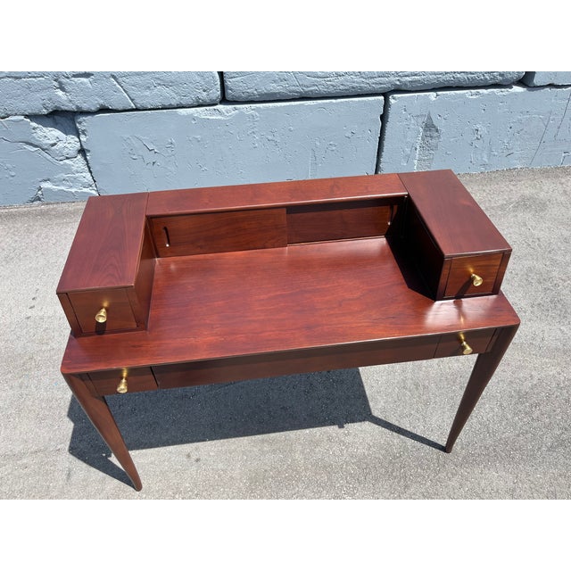 1960s Walnut Desk by T.H.Robsjohn-Gibbings for Widdicomb. The desk has one center drawer and four side drawers with brass...
