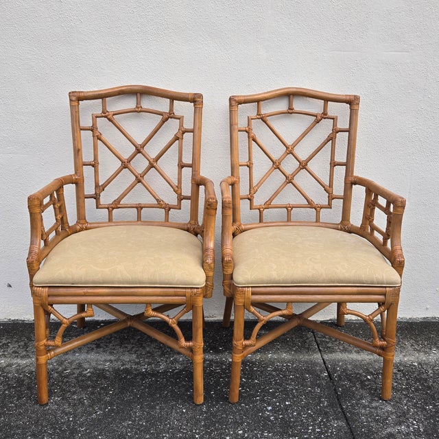 This Chinese Chippendale style set consists of four faux bamboo armchairs, each featuring rattan fretwork on chair backs,...