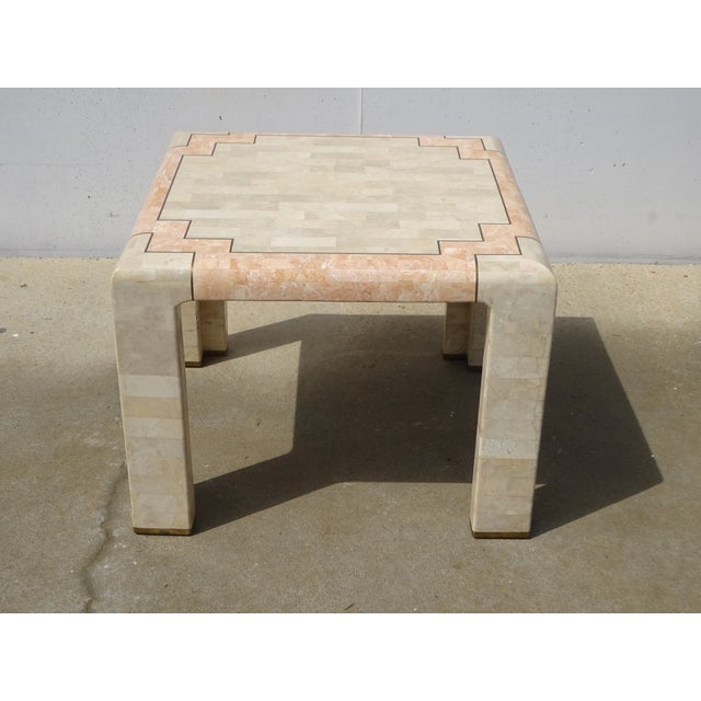 Square tabletop in two colors: ochre and pale pink. Inlaid with two distinct stones, with gilt brass inlays. Four angled...