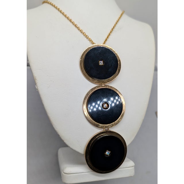 1969 goldtone series of 3 discs with black resin discs on top of them and small round clear rhinestone centers pendant on...