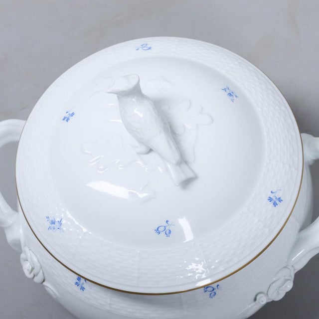 This tureen has a gold-rimmed lid. The piece is richly decorated with painted flowers in blue glaze and very special...