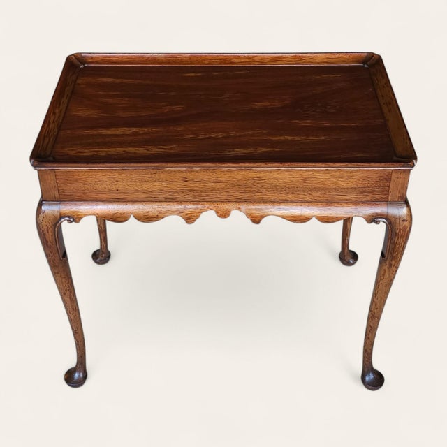 A refined Georgian-style mahogany side table by Kittinger Company, featuring a raised gallery (tray) top, scalloped apron,...