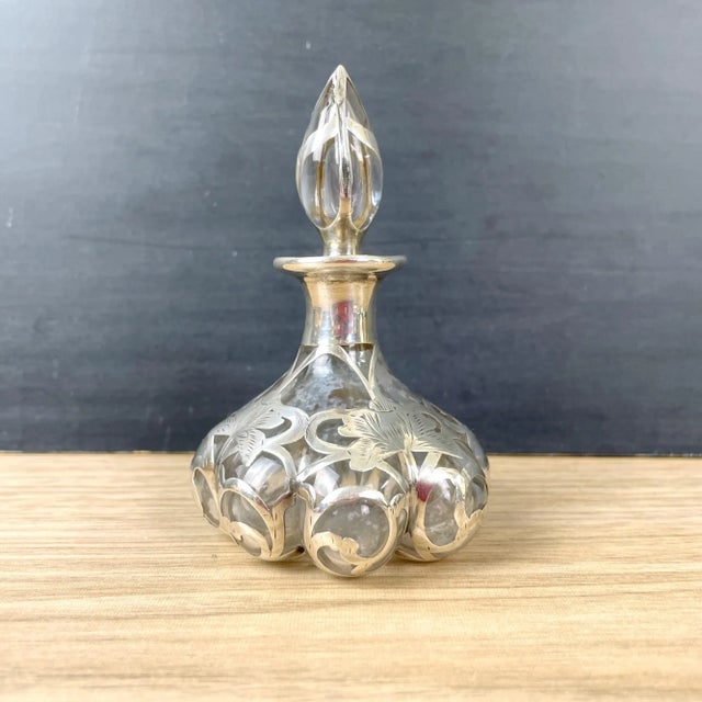 Antique lobed glass perfume bottle with fine sterling overlay etched with flowers. Bottle stopper and bottom are etched...