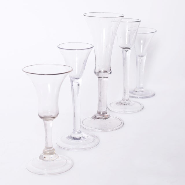 Rare and remarkable set of five hand blown folded and domed foot plain stem wine or liquor glasses in assorted sizes and...