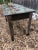 A one of a kind industrial table having wooden top with copper tones underneath a distressed turquoise paint. The legs are...